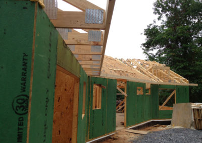 SIP panel walls up during construction with roof framing exposed.