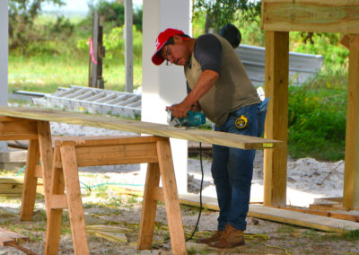 Construction worker cutting conventional lumber on-site.