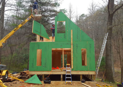 Placing gable-end panels on a SIP home during construction.