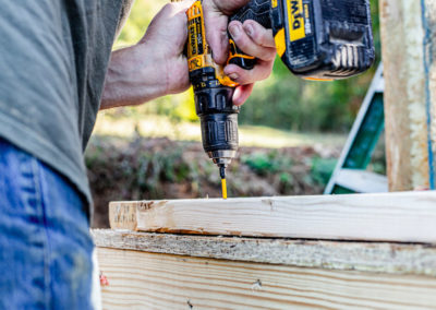 Builder attaching bottom plate to subfloor.